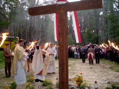 <em><strong>Ks. Leszek Tokarzecki poświęca krzyż na grobie Polaków.</strong></em>