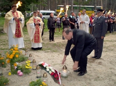 <em><strong>Ambasador RP na Ukrainie dr. Henryk Litwin ustawia znicz na grobie Polaków.</strong></em>